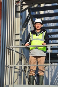 Byung Su Lim, leader of ITER's Poloidal Field Coil Section, posing in front of the completed winding facility. (Click to view larger version...)