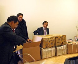 The book donor Luo Delong (right) looking at the precious goods that have just arrived from China. (Click to view larger version...)