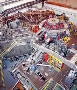 Inside the NSTX test cell: the apple-shaped fusion experiment includes exterior vertical red magnetic coils and horizontal blue magnetic coils. The rectangular steel box to the left of the machine contains the neutral beam system for heating plasma. (Click to view larger version...)