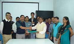 Shishir Deshpande (centre left) handing over the signed document to Biswanath Sakar from the ITER India project team... (Click to view larger version...)