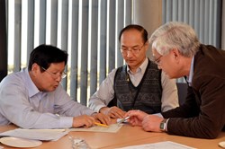Kijung Jung (left) working on a document with Japanese colleagues Hideo Nakajima and Kiyoshi Okuno. (Click to view larger version...)