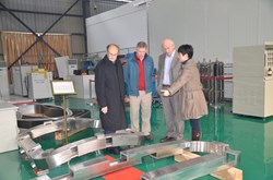 Wei Jing, team leader at ASIPP for the correction coils, showing model cases to Michel Huguet and, from the ITER Organization, Mark Gardner and Adamo Laurenti. One bottom correction coil model case and one side correction coil model case are visible. (Both are of reduced overall size but with full-size cross section.) (Click to view larger version...)