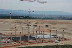 The columns for the Poloidal Field Coil Winding Facility are rising out the ground in the foreground, while the Tokamak Pit is taking shape in the background. (Click to view larger version...)