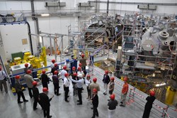 IPP spokesman Robert Wolf showing the group around the Wendelstein W7-X assembly hall. Photo: Ralph Schorn (Click to view larger version...)