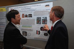 Jiangang Li (left), an eloquent promoter of fusion energy, discussing a poster at last week's SOFE. (Click to view larger version...)