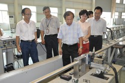 A team from the Chinese Domestic Agency, led by Director Luo Delong (centre), witnesses the welding of the dummy conductor. (Click to view larger version...)