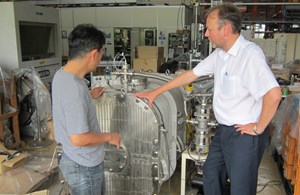 Takahashi-san shows the heating oven that will be used for further testing of the mockup to ITER Akko Maas. (Click to view larger version...)