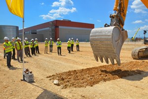 A large excavator symbolically scratched the earth where the 26-metre-high, 110-metre-long Cryostat Workshop will soon be erected. (Click to view larger version...)