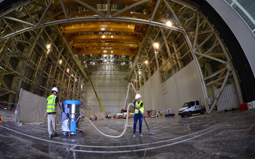 In the 60-metre-tall building for pre-assembly activities, workers go over the painted surface of the basemat. Later, when construction activities on the Tokamak Building are finalized, the temporary wall seen at the end of the building will come down and the cranes will operate along a 170-metre crane bay. The double building will operated as a clean space during the assembly of the machine. (Click to view larger version...)