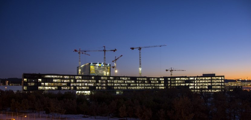 Behind the lit offices of the ITER Headquarters building, with desks for 800 people, the scientific installation is rising. (Click to view larger version...)