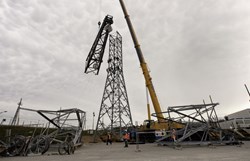 One by one, the four pre-assembled ''arms'' of the pylon were hoisted to the frame and bolted by a team of eight specialists in acrobatic works. (Click to view larger version...)