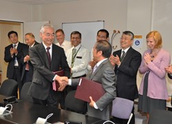 ITER DG Osamu Motojima and his Chinese counterpart, Luo Delong, shaking hands after signing PAs # 54 and 55. The team that accomplished the framework for these two contracts is watching the event. (Click to view larger version...)