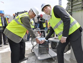 ITER Director-General Motojima and Laurent Schmieder, of the European Domestic Agency, press the switch that finalizes the installation of the 493rd and final seismic pad in the Tokamak Pit. (Click to view larger version...)