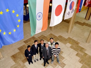 The second group of Monaco Fellows stands below the ITER Member flags with David Campbell, head of the Plasma Operation Directorate. (Click to view larger version...)