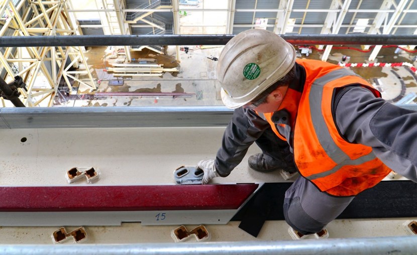 43 metres above the basemat of the Assembly Hall, workers are laying the rails for the lifting system that will handle components weighing up to 1,500 tonnes. (Click to view larger version...)