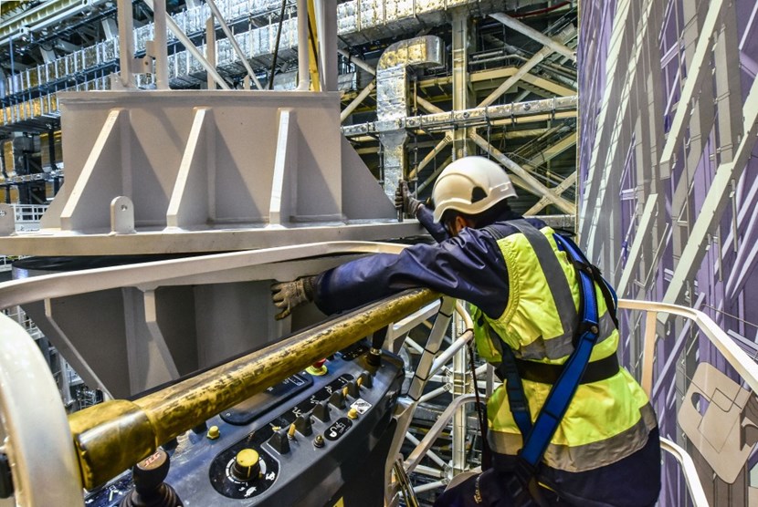 Positioned on both sides of the beam, CNIM specialists precisely align the suspended beam and the massive supporting pillars—an operation that can only be performed manually. (Click to view larger version...)
