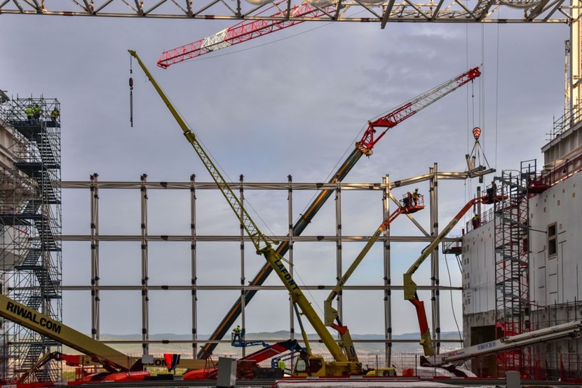 Like in a mechanical ballet, workers on elevated platforms are installing the elements of the north wall steel framework. Another four days and it will be completed. (Click to view larger version...)