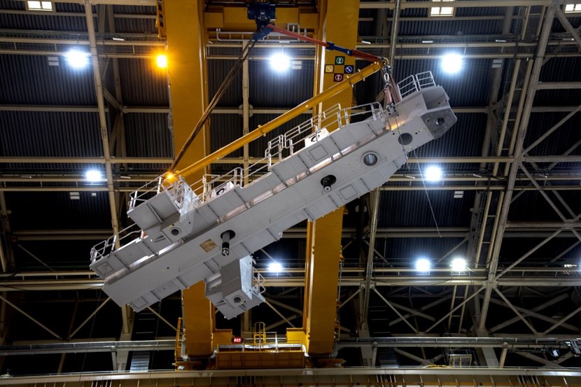 Radial beams will arrive in the pit supporting each vertical vacuum vessel sub-assembly as it travels by overhead crane. Their precise positioning is paramount for the alignment of the machine torus. (Note the figure on the small screen between the crane beams: the component and its rigging weigh exactly 80.9 tonnes.) (Click to view larger version...)