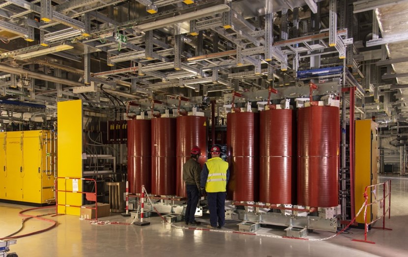 One of the two sets of high-voltage power supplies already installed on the second floor of the Radio Frequency Building. The red cylinders are ~6MW cast-resin multi-secondary transformers that feed the power modules to the left (yellow). (Click to view larger version...)