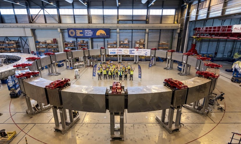Inside the ''large onsite factory'' put together to accommodate the manufacturing of the four largest ITER poloidal field coils, representatives of the European Domestic Agency Fusion for Energy and its six contractors celebrate the finalization, in July 2023, of poloidal field coil #4. (Click to view larger version...)